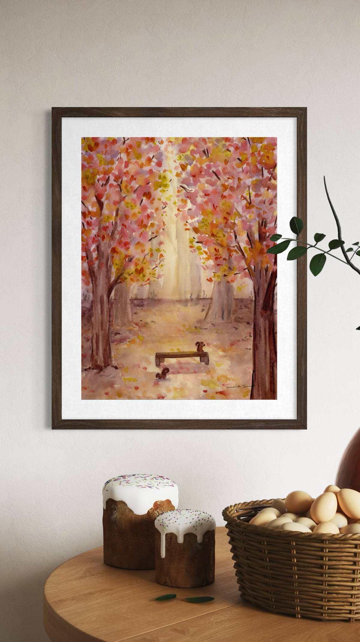 Original watercolor painting of a sunlit autumn forest path with vibrant pink, yellow, and orange foliage framing a wooden park bench with two squirrels.