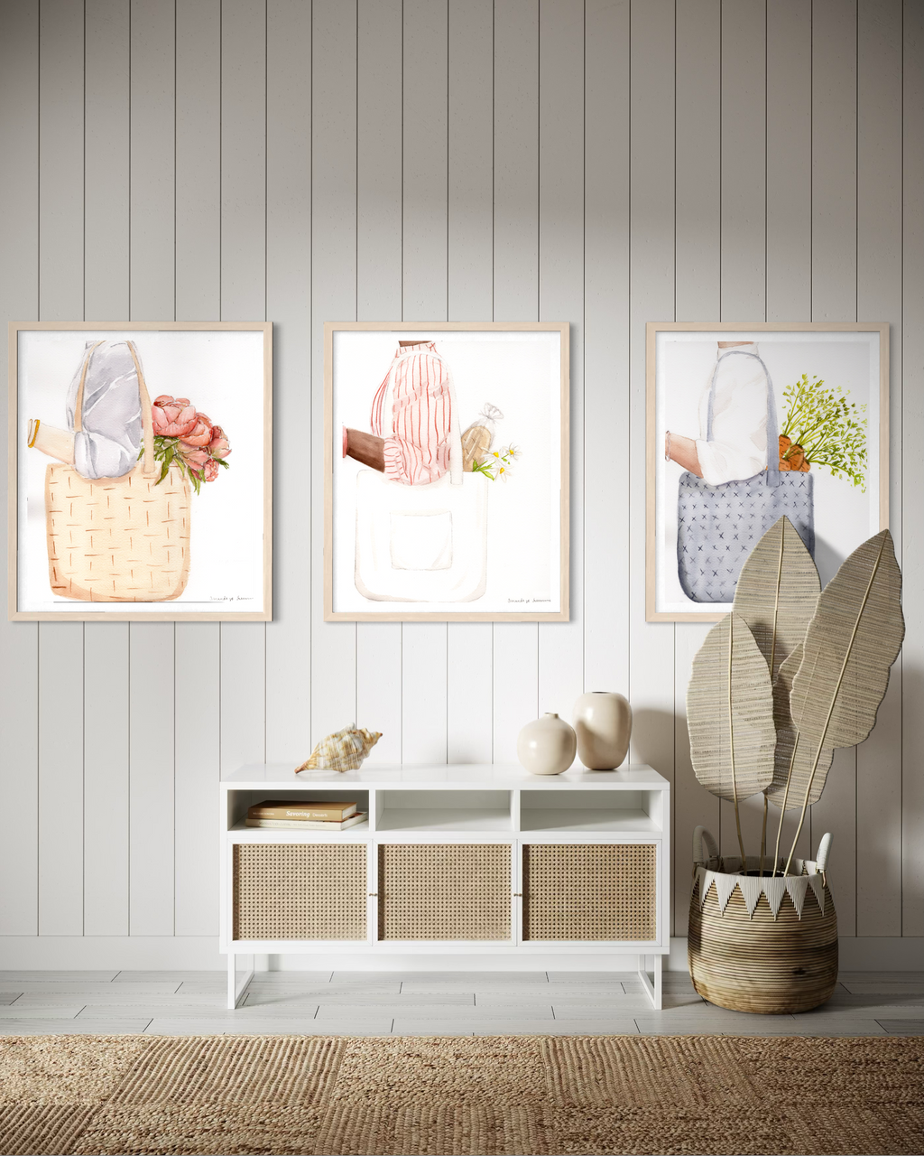 A triptych display of three minimalist watercolor paintings staged side-by-side on a neutral off-white wall. The collection, titled the Farmers Market Collection, features hand-painted illustrations of market totes with a spring aesthetic. The left panel shows a woven straw tote with coral peonies; the center panel shows a person in a red striped shirt carrying a white canvas tote with a baguette and daisies; and the right panel shows a blue textured bag with fresh carrots. The clean, modern gallery wall se
